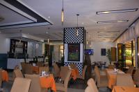 Un restaurante con mesas y sillas y un bar. en Sun View Hotel, en Addis Ababa