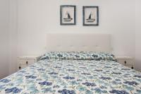 a bed in a bedroom with three pictures on the wall at Apartamento Lance Playa in Tarifa
