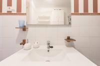 a white sink in a white tiled bathroom at Apartamento Lance Playa in Tarifa