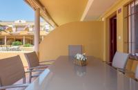 a table with chairs and a vase of flowers on it at Apartamento Lance Playa in Tarifa