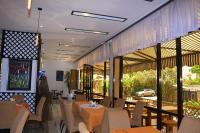 Un restaurante con mesas y sillas y grandes ventanales. en Sun View Hotel, en Addis Ababa