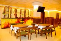 印多尔THE CLAN HOTEL - VIJAY NAGAR Indore的一间配有桌椅和电视的餐厅