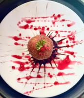 a white plate topped with a dessert with red sauce at GOOSENECK HOTEL and RESTAURANTS in Kandogal