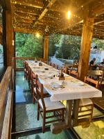 Un comedor largo con una mesa larga y sillas. en Hotel - Resort Vellezerit Doka, en Klos