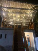 Un hombre parado en un balcón de un edificio con escaleras. en Arsilahomestay, en Tetebatu