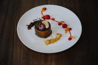 Un plato blanco con un postre de chocolate sobre una mesa. en AMERON Hamburg Hotel Speicherstadt, en Hamburgo