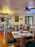 サン・フアン・デル・リオにあるHotel Portal de Reyesの白いテーブルと椅子のあるダイニングルーム