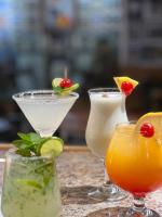 サン・フアン・デル・リオにあるHotel Portal de Reyesのテーブルの上にはライムと飲み物が置かれたカクテルが3つ置かれている