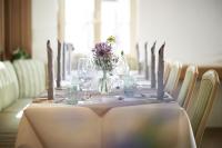 una mesa con vasos y un jarrón con flores. en Hotel Nassauer Hof, en Limburg an der Lahn