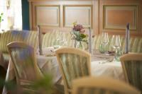 una mesa con vasos y un jarrón de flores. en Hotel Nassauer Hof, en Limburg an der Lahn