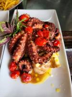 Un plato blanco de comida con salchichas y tomates. en Casa da Ilha & SPA, en Abraão