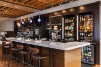 鲍德温公园鲍德温公园万怡酒店的餐厅里的酒吧，配有吧台凳