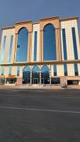 a large building with windows on the side of a street at التاج ثلاثة الفندقية in An Nikāshah