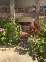 un porche de una casa con flores y plantas en Oasis Kemba Hôtel-Restaurant-Bar, en Toliara