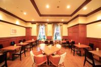 een eetkamer met houten tafels en stoelen bij Quintessa Hotel Sasebo in Sasebo