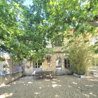 ein altes Steingebäude mit einer Bank davor in der Unterkunft Le Mas de Lucas in Arles
