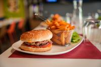 Un plato con una hamburguesa y papas fritas en una mesa. en ibis budget Sète centre, en Sète