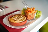 Un plato de comida con un tazón de salsa y papas fritas en ibis budget Sète centre, en Sète