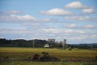ein Feld mit einem großen Gebäude in der Ferne in der Unterkunft Le Mas de Lucas in Arles