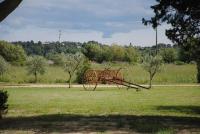 eine rote Bank mitten auf einem Feld in der Unterkunft Le Mas de Lucas in Arles