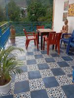 a patio with a table and chairs and a table at Rumis Mountain Sunset in Nainital
