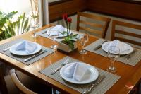 a wooden table with white plates and glasses on it at Mato Grosso Palace Hotel in Cuiabá