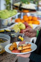 a person holding a plate of food on a table at Tugra Suit Hotel Halal All Inclusive in Alanya