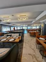 a dining room with tables and chairs in a restaurant at Golden Stone Hotel Akçay in Edremit