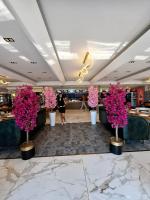 a lobby with pink flowers in white vases at Golden Stone Hotel Akçay in Edremit
