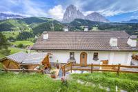 una casa blanca con montañas al fondo en Apartments Rondula Pic, en Santa Cristina Valgardena