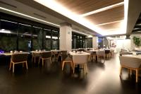 un ristorante con tavoli e sedie bianchi e finestre di Quartz Care Hotel & Spa Tijuana a Tijuana