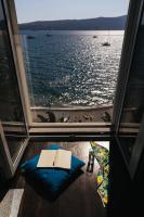 Un libro sobre una almohada frente a una ventana. en Hotel Palma, en Tivat