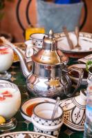 a tea kettle on a table with cups and plates at Riad Mazouz102 Médina in Marrakech
