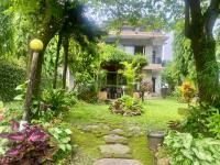 a garden in front of a large house at Cherry Garden Pokhara in Pokhara