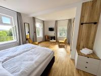 Un dormitorio con una gran cama blanca y un escritorio. en Backbord Geesthacht, en Geesthacht