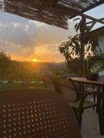 a table and chairs with the sunset in the background at Mosaic Guesthouse in Lin