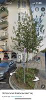 a car parked in front of a building with a tree at Nordhavn Cozy Room in shared apartment in Copenhagen