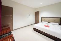 Un dormitorio con una cama con una maleta roja. en Urbanview Hotel Wongso Pangkal Pinang, en Pangkalpinang