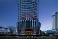 Un edificio alto con un cartel encima. en Hilton Garden Inn Urumqi Railway Station, en Ürümqi
