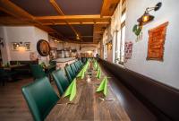 a long table in a restaurant with green chairs at Hotel Perlach Allee by Blattl in Munich
