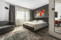 una habitación de hotel con una cama y un sofá en Qubus Hotel Gorzów Wielkopolski, en Gorzów Wielkopolski