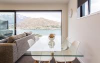 ein Esszimmer mit einem Glastisch und weißen Stühlen in der Unterkunft Highland Views in Queenstown