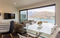 ein Wohnzimmer mit einem Tisch und Stühlen sowie einem großen Fenster in der Unterkunft Highland Views in Queenstown