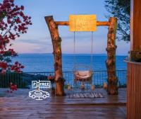 Un columpio en una terraza con el océano de fondo en PARADISE Bay Hotel, en Sozopol