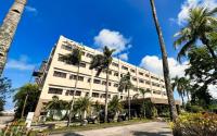 Un gran edificio con palmeras delante. en Acacia Hotel Bacolod, en Bacolod