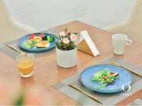 a table with two plates of food and a drink at Orange Hotel Beijing Qianmen Street in Beijing