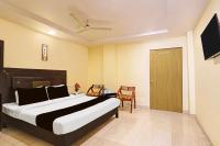 Un dormitorio con una cama y una mesa y una puerta. en Collection O Kurnool Formerly Sai Priyanka Inn, en Kurnool