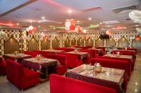 a restaurant with red chairs and tables and balloons at Hotel Amrapali Classic in Bhawānipatna