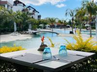 a table with utensils on it next to a pool at Choisy Les Bains D2 by Host Agents in Mont Choisy