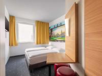 una habitación de hotel con una cama y un escritorio en B&amp;B Hotel Dresden-Messe, en Dresden